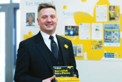 An image of an employee offering Marie Curie daffodil badge.