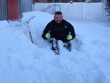 John Paul Kane digging snow at the back door of the hub.